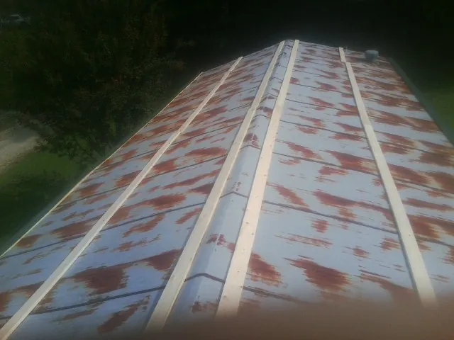 Rusted metal roof panels with new wood purlins before replacement — Storm Damage Roof Repair in Cayce by Roofing Brothers
